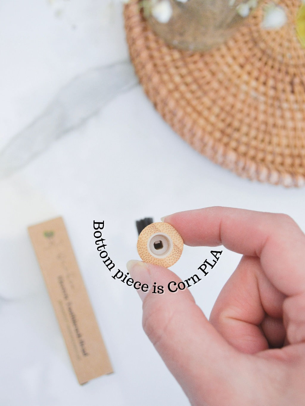 Hand holding bamboo electric toothbrush head and box